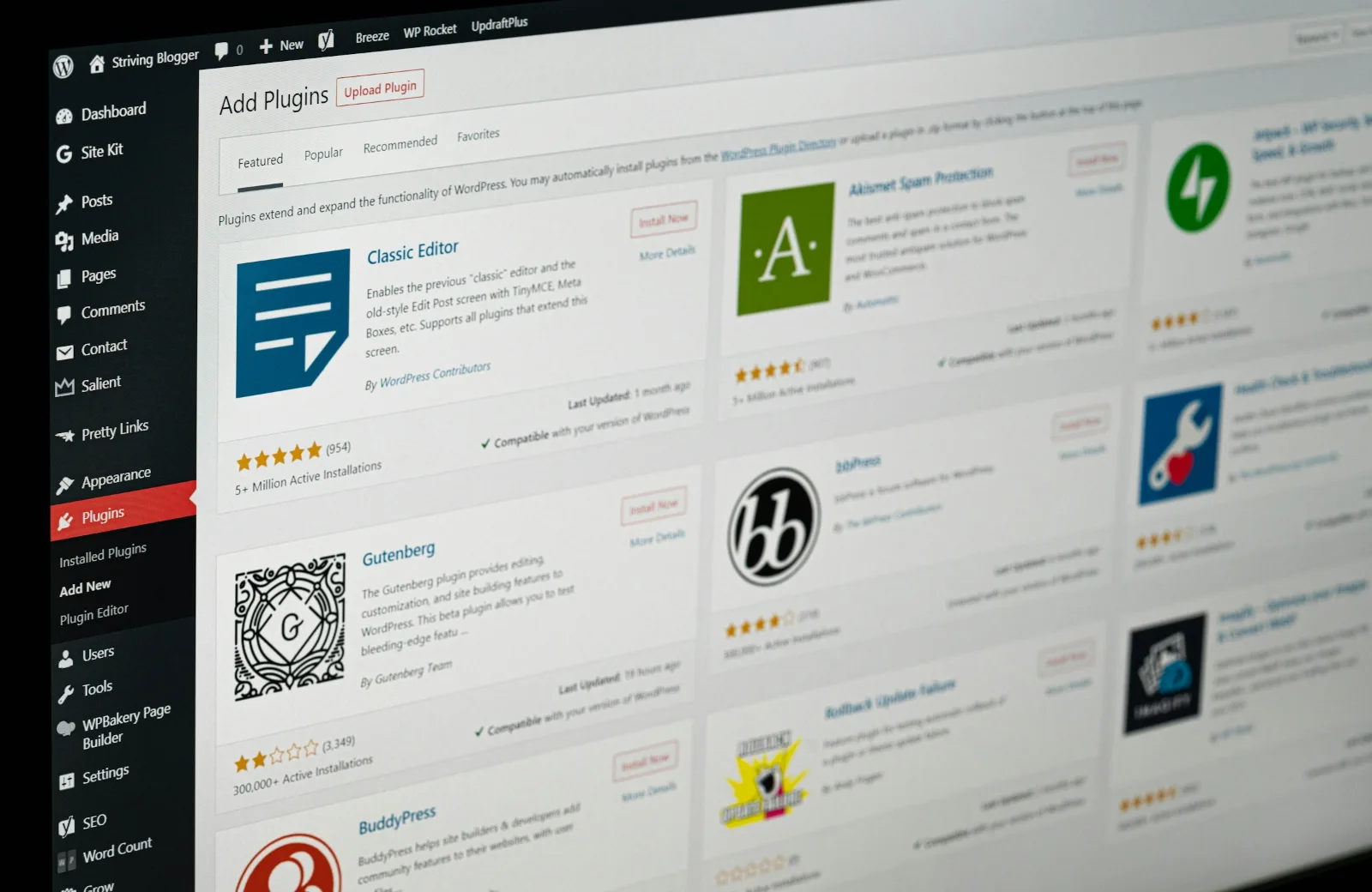 WordPress admin dashboard on a screen, showing the sidebar menu and the Add Plugins page